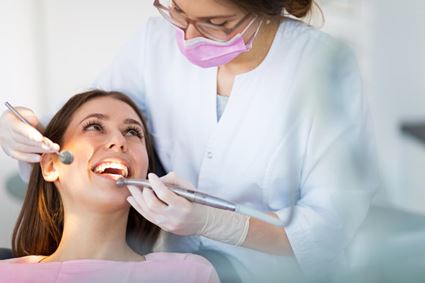 tandartsassistent voert behandeling uit bij patiënt