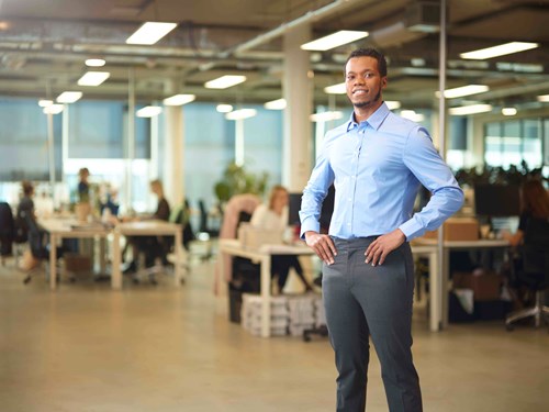 Accountmanager staat lachend in kantoortuin