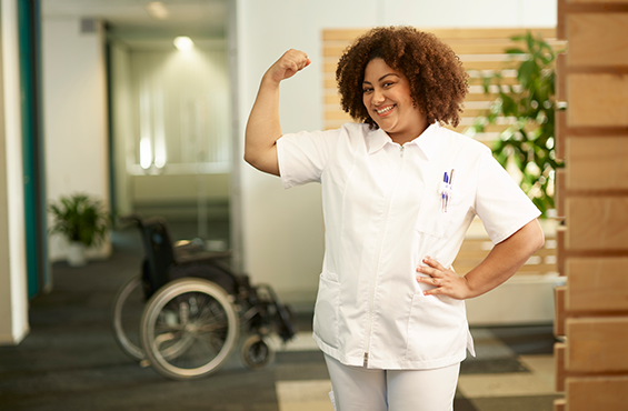Verzorgende staat poserend voor camera in de gang 