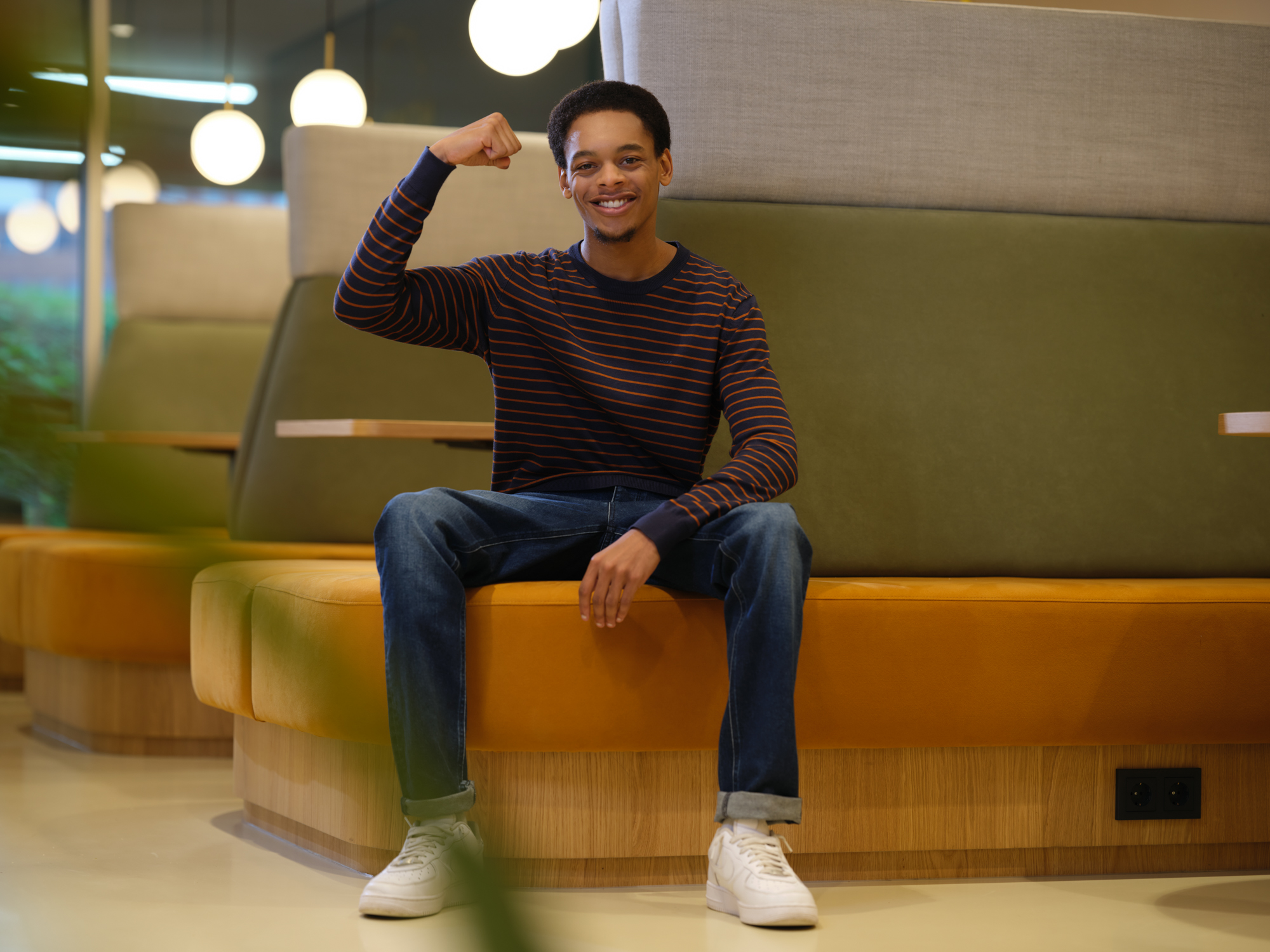 Man zit op een bank en houdt zijn gebogen arm omhoog