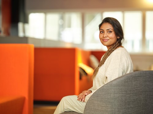 Capabel Onderwijs student zit glimlachend op bankje 