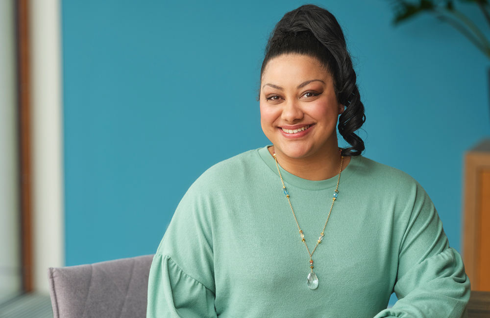 Sociaal werker zit op stoel en lacht 