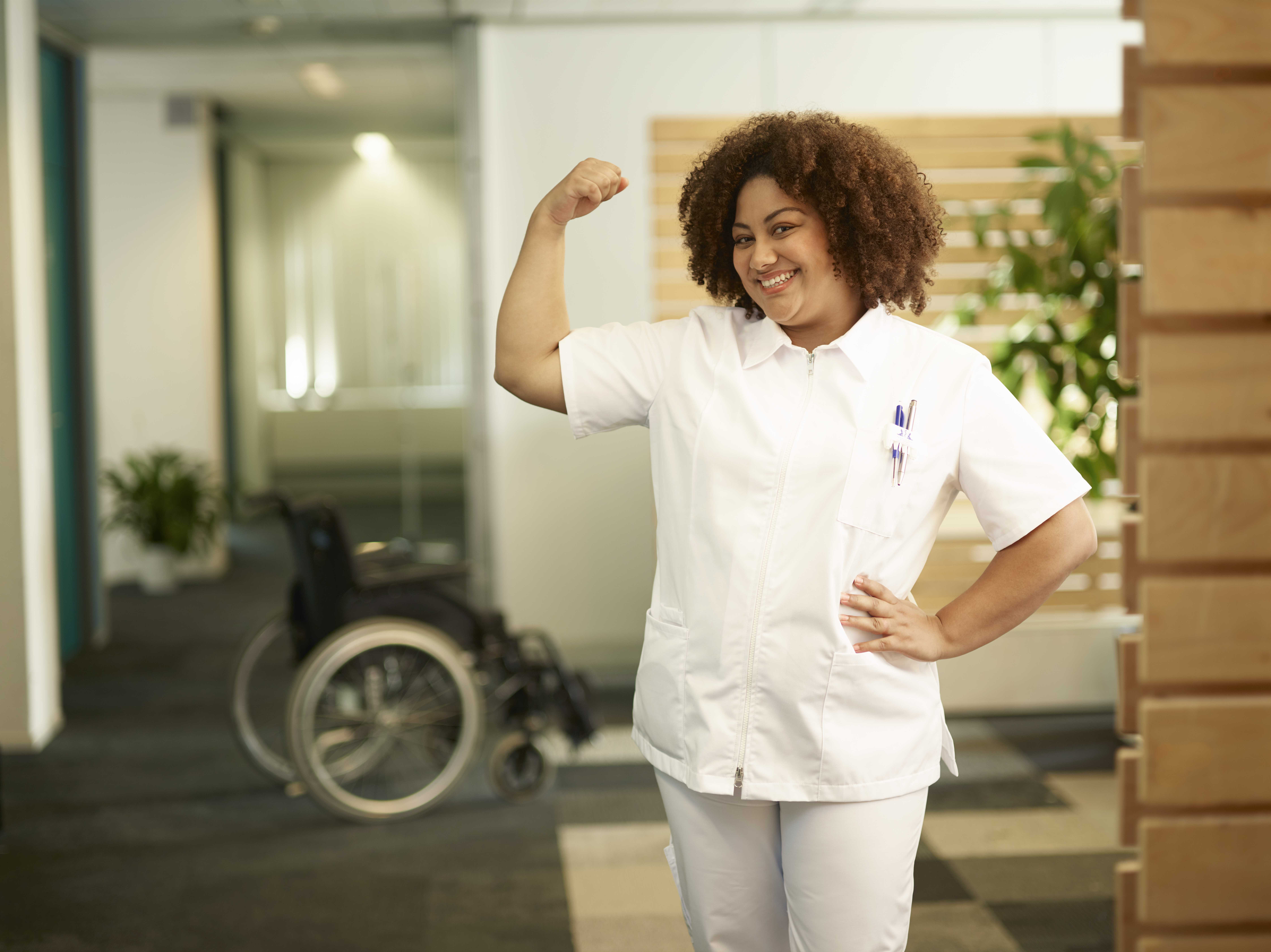 Verzorgende staat lachend met spierbal