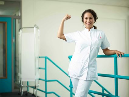 Verpleegkundige toont lachend haar spierbal voor camera