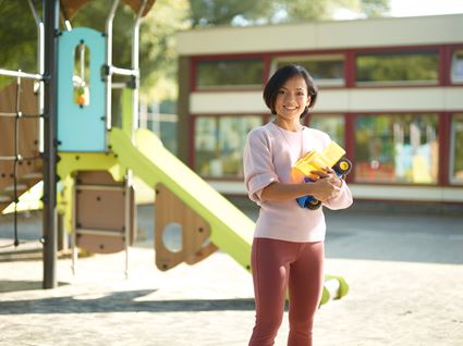 Onderwijs en kinderopvang student staat in speeltuin