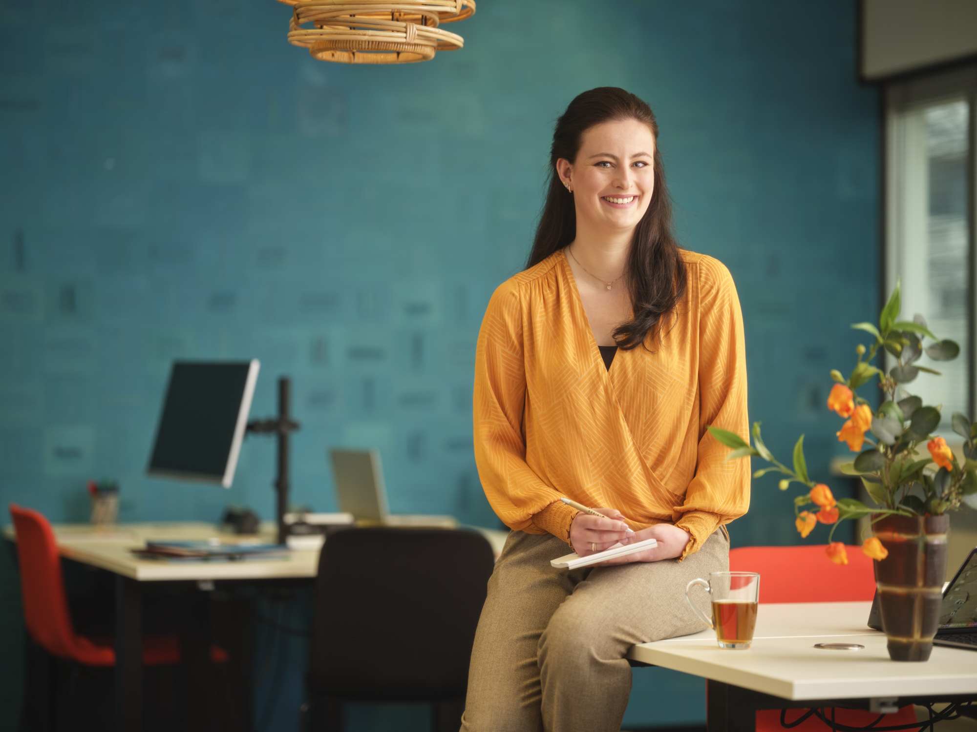 Arbeidsdeskundige zit op haar bureau met schrift