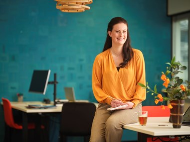 Arbeidsdeskundige zit op haar bureau met schrift