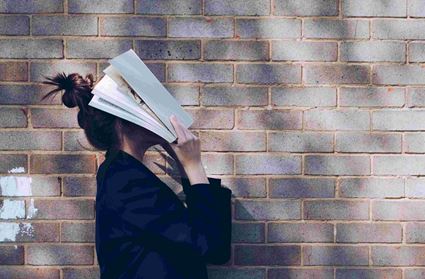 Student Capabel Onderwijs verstopt gezicht in boek